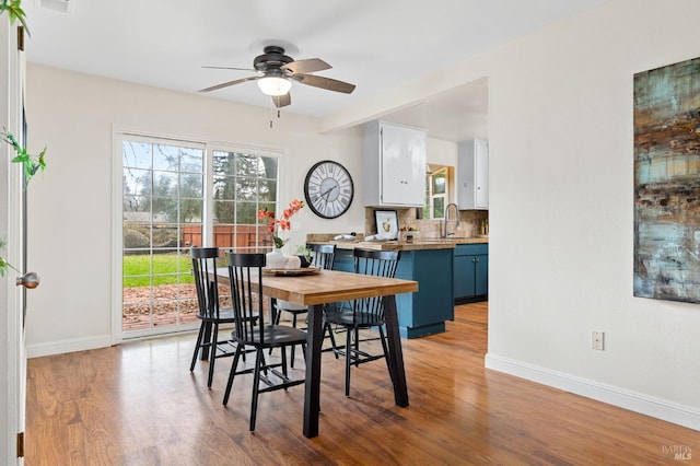 dining room with ceiling fan, wood finished floors, and baseboards