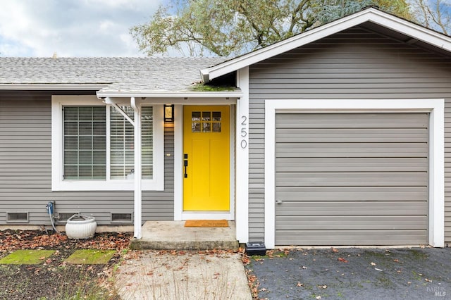 property entrance featuring aphalt driveway, crawl space, roof with shingles, and an attached garage