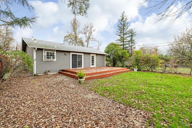 back of house featuring a lawn, a wooden deck, and fence