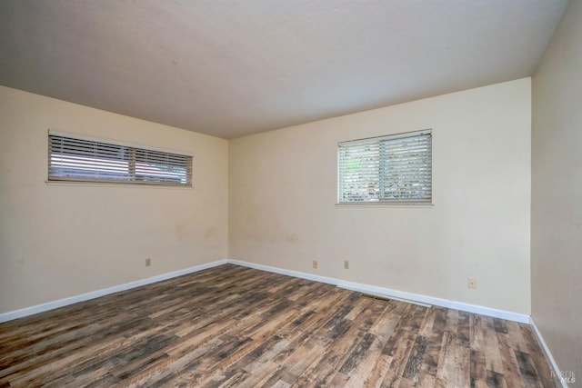 unfurnished room with dark wood-type flooring