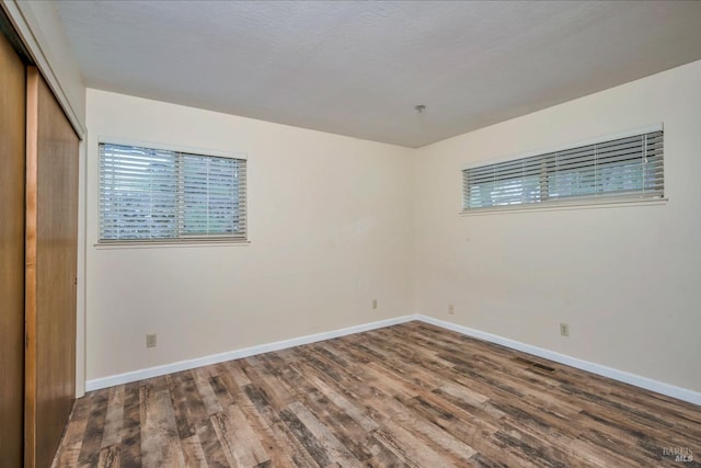 unfurnished bedroom featuring dark hardwood / wood-style floors and a closet