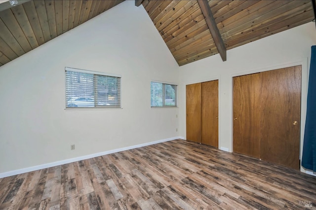 unfurnished bedroom featuring beam ceiling, hardwood / wood-style flooring, high vaulted ceiling, wooden ceiling, and multiple closets