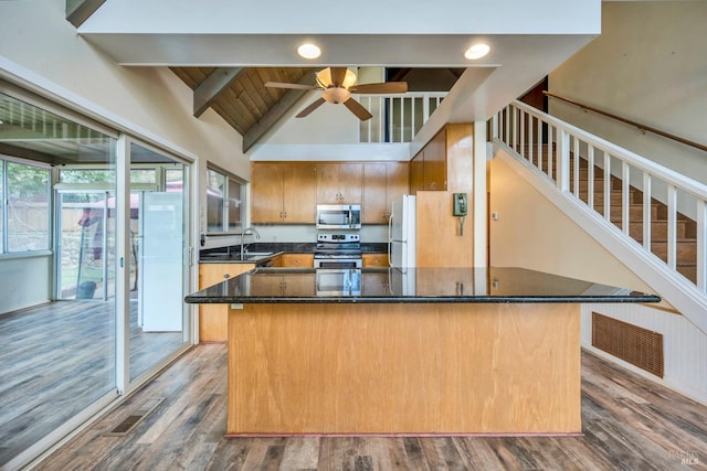 kitchen with sink, ceiling fan, beamed ceiling, dark hardwood / wood-style flooring, and stainless steel appliances