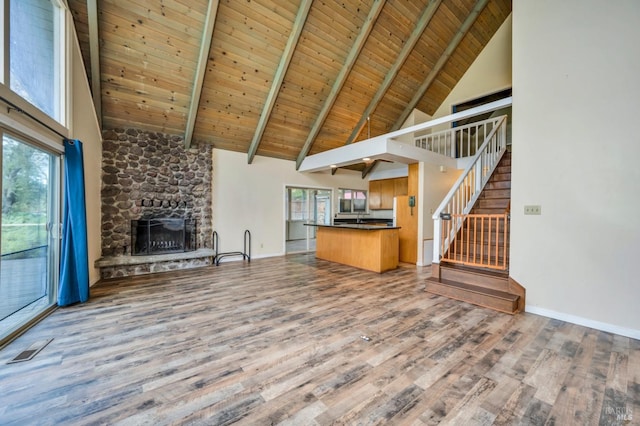 unfurnished living room featuring wooden ceiling, beamed ceiling, high vaulted ceiling, wood-type flooring, and a fireplace