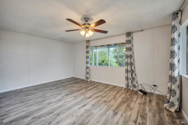 unfurnished room featuring hardwood / wood-style flooring, ceiling fan, and a textured ceiling