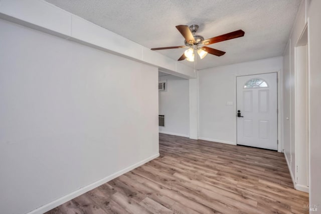 entryway with ceiling fan, a textured ceiling, and hardwood / wood-style flooring