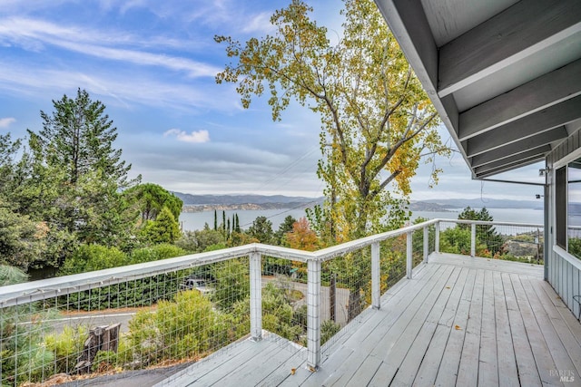 deck with a water and mountain view