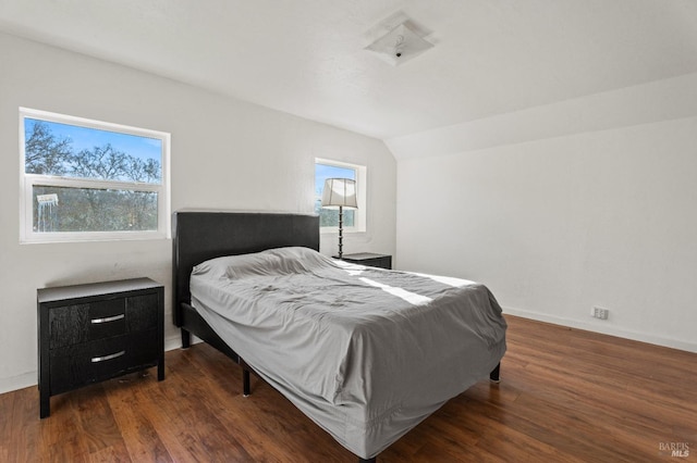 bedroom featuring lofted ceiling, dark wood-type flooring, and multiple windows