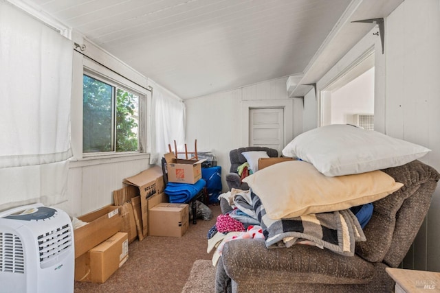 bedroom with carpet, vaulted ceiling, and wood walls