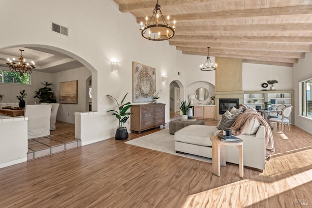 living room with hardwood / wood-style flooring, wooden ceiling, a wealth of natural light, and a notable chandelier