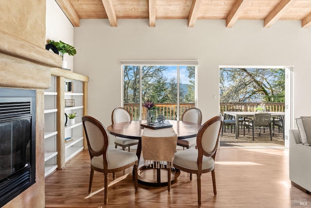 dining room featuring hardwood / wood-style floors, wooden ceiling, and beam ceiling