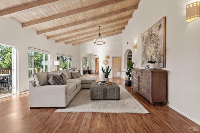 living room with an inviting chandelier, high vaulted ceiling, wood-type flooring, wood ceiling, and beam ceiling