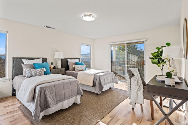 bedroom with access to exterior and light hardwood / wood-style flooring