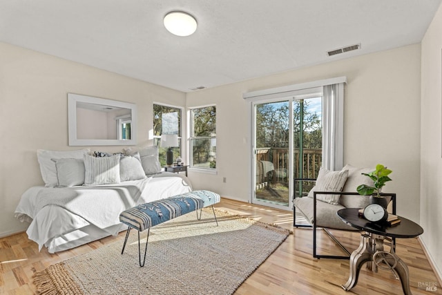 bedroom featuring wood-type flooring and access to exterior