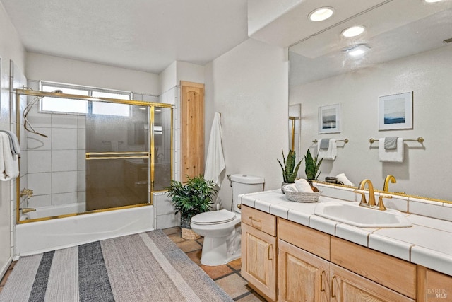 full bathroom with toilet, vanity, and shower / bath combination with glass door