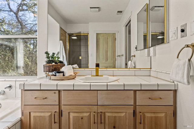 bathroom featuring vanity and tiled bath