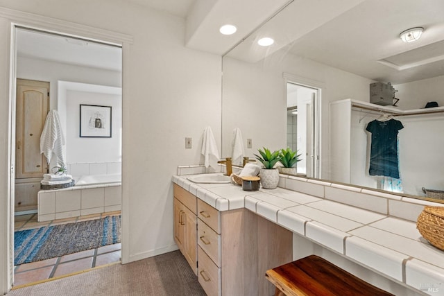 bathroom featuring vanity and a relaxing tiled tub