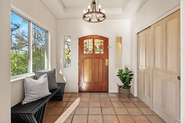 entrance foyer featuring an inviting chandelier and a raised ceiling