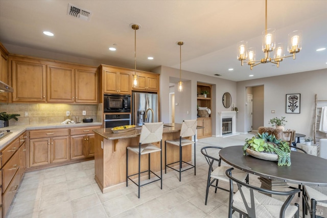 20 Oak Grove Dr, Novato, CA 94949 - kitchen featuring tasteful backsplash, a kitchen breakfast bar, appliances with stainless steel finishes, a glass covered fireplace, and visible vents