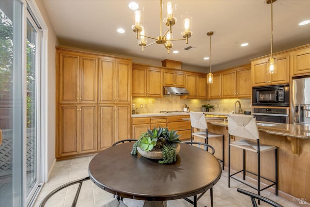20 Oak Grove Dr, Novato, CA 94949 - kitchen with decorative light fixtures, light tile patterned floors, under cabinet range hood, decorative backsplash, and appliances with stainless steel finishes