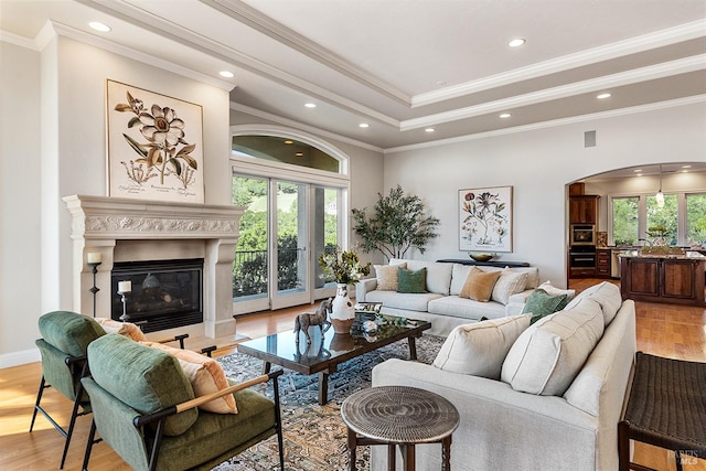 living room with plenty of natural light, ornamental molding, and light hardwood / wood-style floors