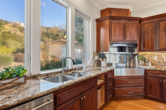 kitchen with dishwasher, stovetop, sink, backsplash, and light wood-type flooring