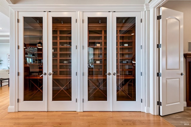 interior space featuring hardwood / wood-style flooring, crown molding, and french doors