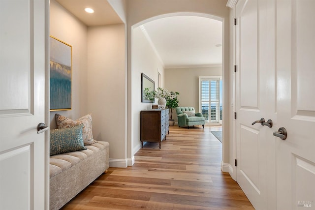 hall with crown molding and light hardwood / wood-style floors