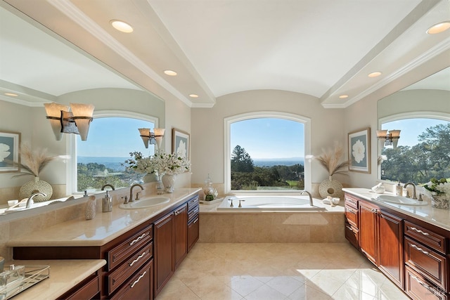 bathroom with tiled tub, vanity, and tile patterned flooring