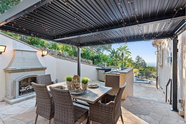 view of patio featuring exterior kitchen and an outdoor fireplace