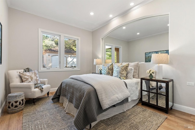 bedroom featuring light hardwood / wood-style floors, multiple windows, and ornamental molding