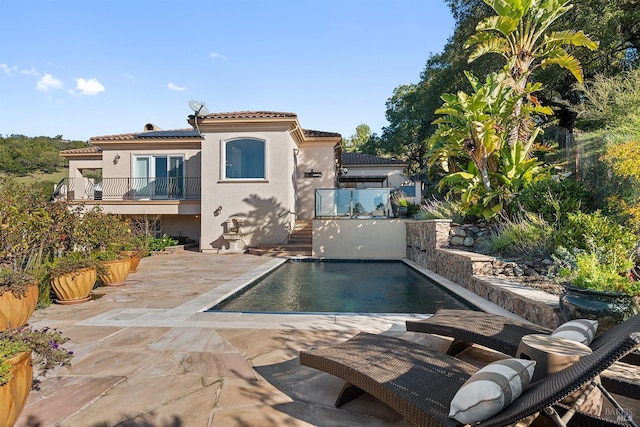 back of house with a balcony and a patio