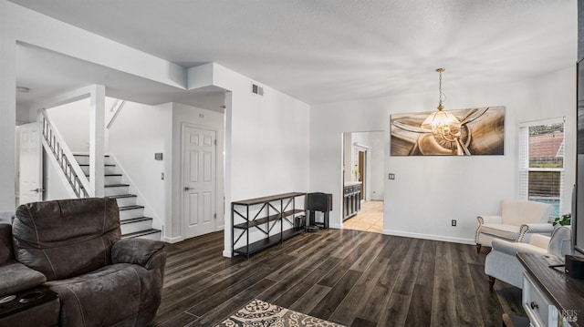 sitting room with dark wood-type flooring and a notable chandelier