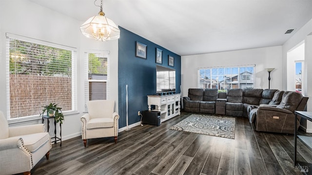 living room with dark hardwood / wood-style floors, plenty of natural light, and a notable chandelier