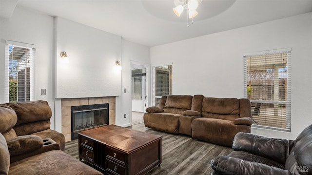 living room featuring a wealth of natural light, ceiling fan, wood-type flooring, and a tile fireplace