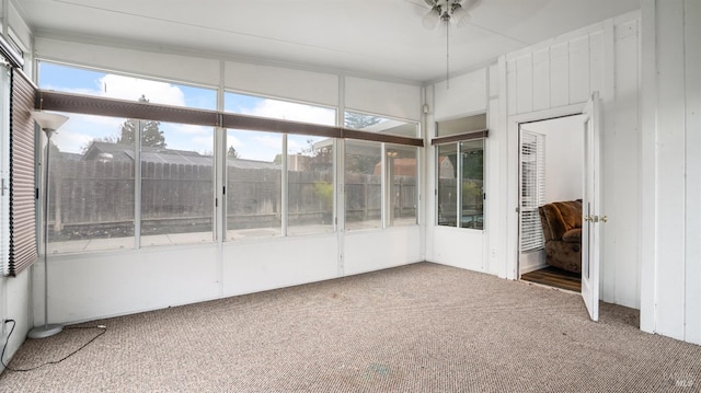 unfurnished sunroom featuring ceiling fan