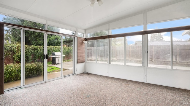 unfurnished sunroom with plenty of natural light, ceiling fan, and lofted ceiling