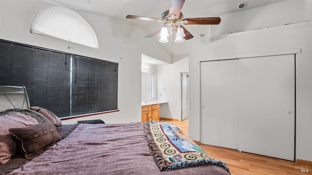 bedroom featuring light wood-type flooring, ensuite bathroom, ceiling fan, a closet, and lofted ceiling