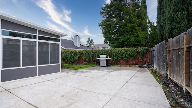 view of patio featuring a grill and a sunroom