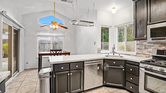 kitchen with decorative backsplash, stainless steel appliances, ceiling fan, sink, and lofted ceiling