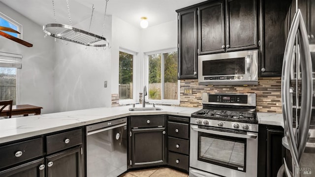 kitchen with backsplash, sink, stainless steel appliances, and plenty of natural light