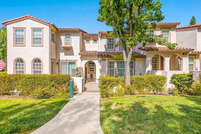 mediterranean / spanish-style house featuring a front yard