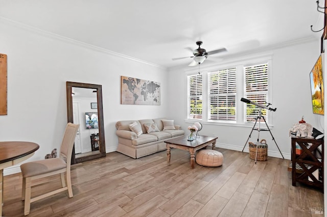 living room featuring light hardwood / wood-style floors, ceiling fan, and crown molding