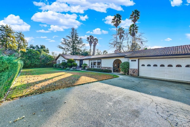 ranch-style house with a garage and a front lawn