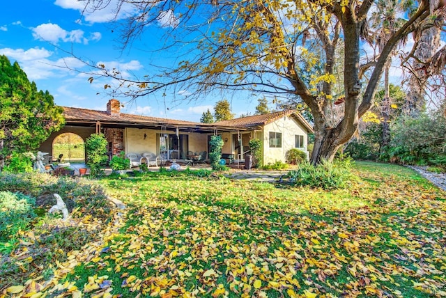 rear view of house with a lawn, ceiling fan, and a patio area