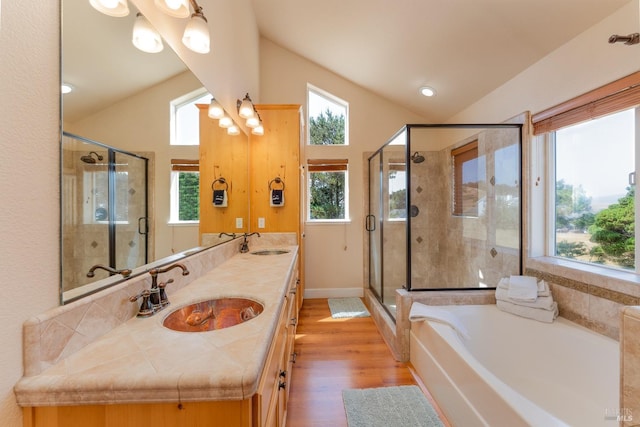 full bath featuring lofted ceiling, a stall shower, a garden tub, and a sink