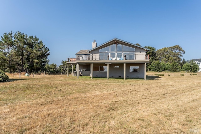 back of property with crawl space, a chimney, and a lawn