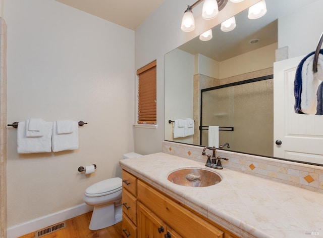 bathroom with visible vents, baseboards, toilet, vanity, and a shower stall