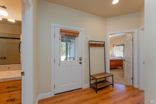 foyer featuring light wood-style flooring and baseboards