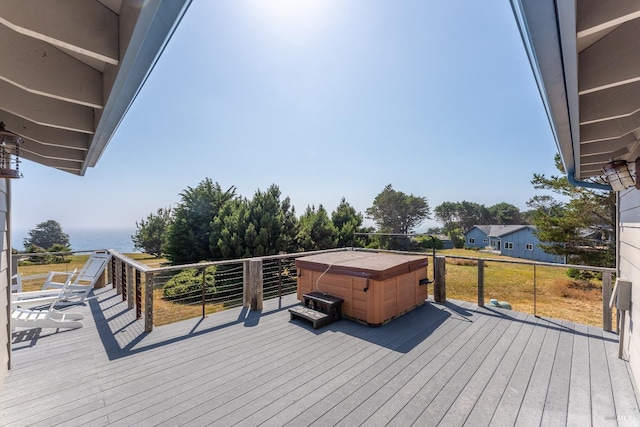 wooden deck featuring a water view and a hot tub